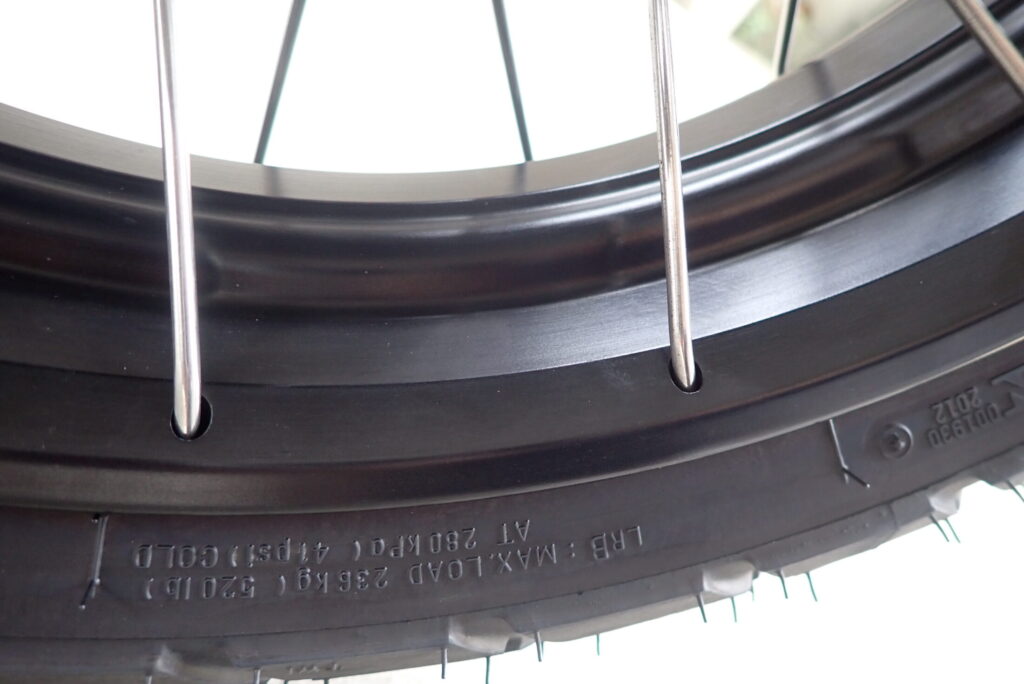 Glossy matte black rim of a Honda X-ADV front wheel after applying SurLuster Zero Finish coating.