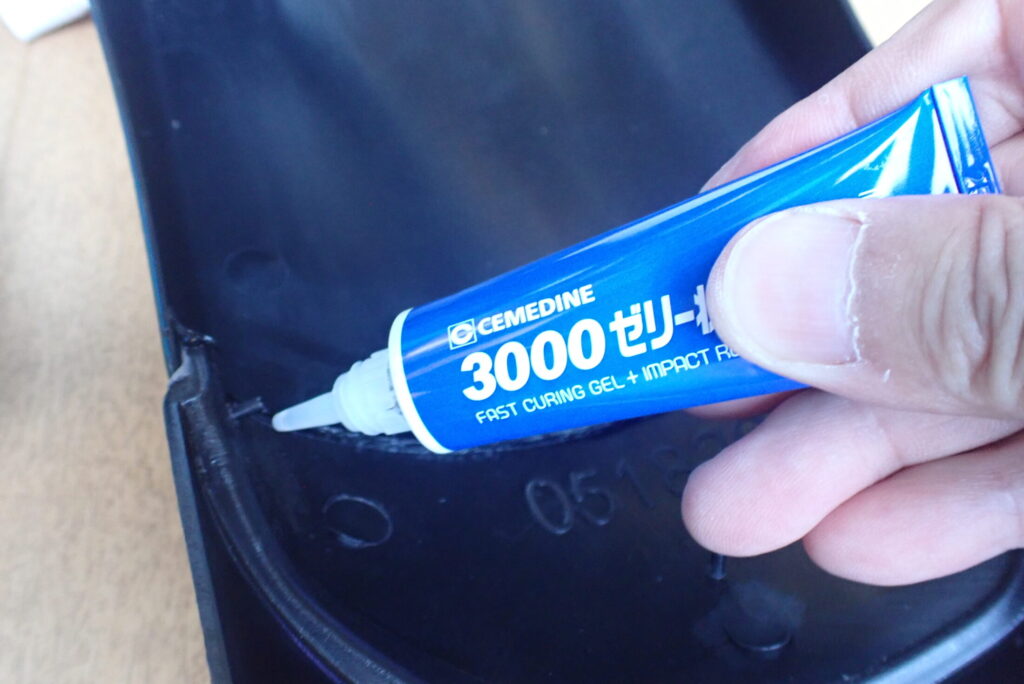 Applying Cemedine 3000 fast-curing gel instant glue onto the lock pin inside the motorcycle fender to prevent loosening.