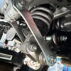 Underbody view focusing on the rear suspension linkage pivot bolts and collars ready for DIY greasing maintenance.