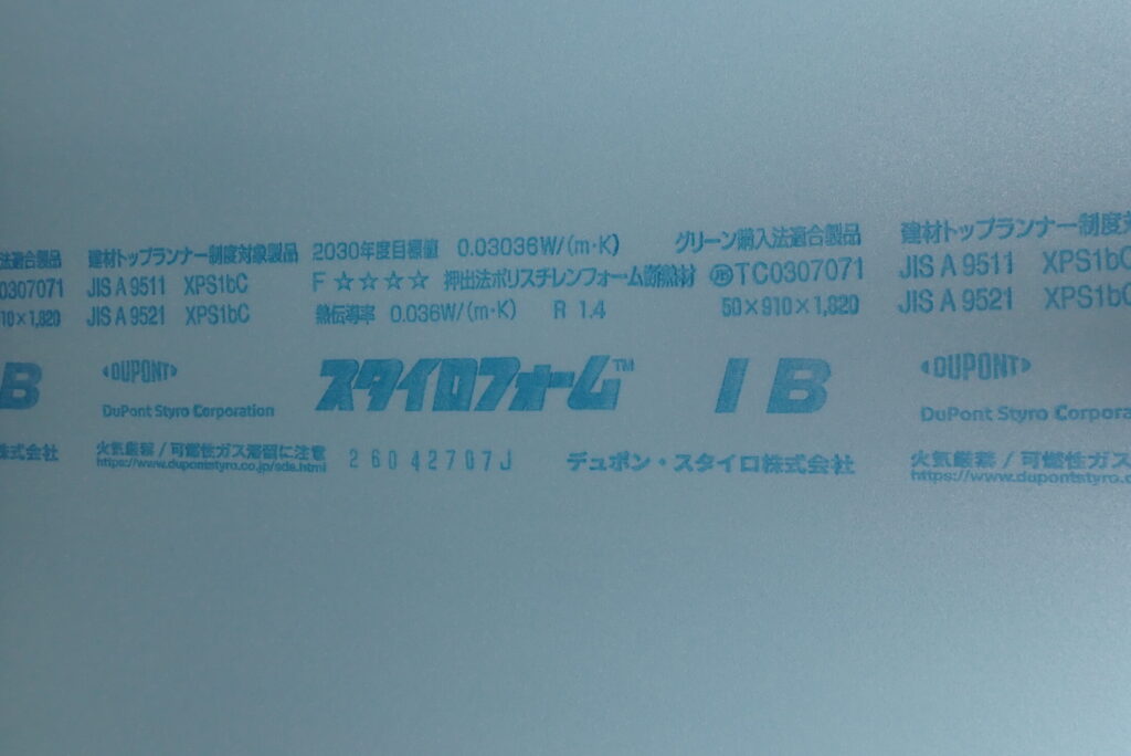 Close-up view of the printed specifications and DuPont Styrofoam IB logo on the surface of the blue extruded polystyrene foam sheet.