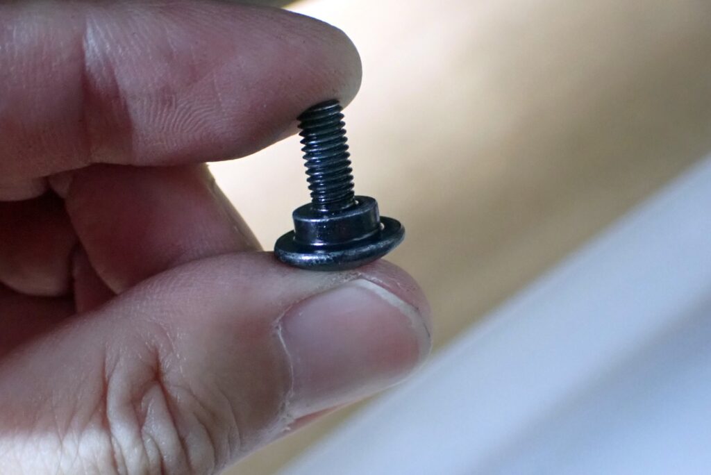 Extreme close-up of a Honda genuine shoulder flange bolt used for securing plastic body panels without crushing them.