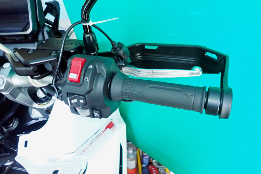 The right handlebar controls of a Honda X-ADV showing the electronic throttle-by-wire system housing and mode switches.
