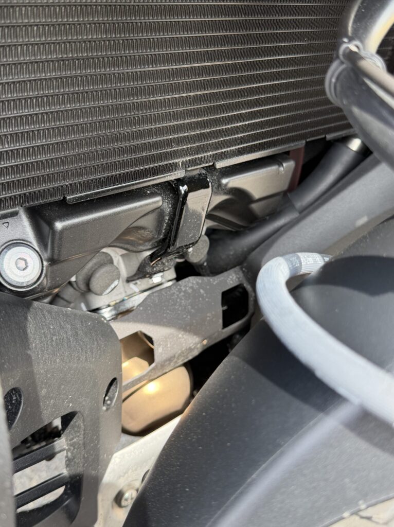 Front view of a Honda X-ADV 750 radiator and exhaust after 100km ride on wet roads, showing minimal mud stains due to the fender extender.