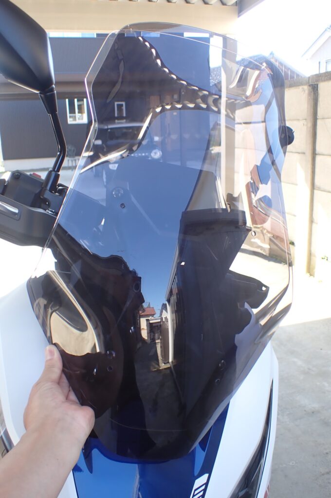 Front view profile of a Honda X-ADV 750 motorcycle, temporary matching an aftermarket smoked touring windscreen.