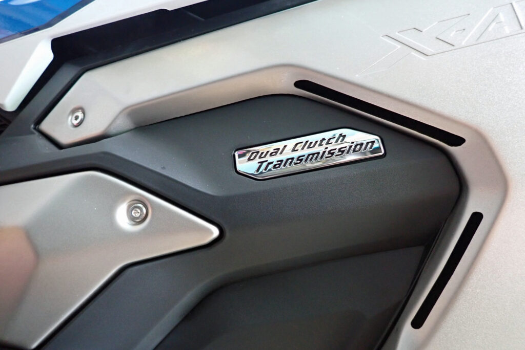 Close-up view of the Dual Clutch Transmission DCT logo casing on the left side of a Honda X-ADV motorcycle engine.