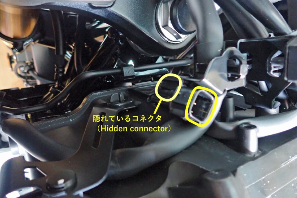 Yellow circles highlighting the main ignition switch and fuel/seat opener button wire harness connectors located near the steering stem nut required to disconnect the center cowl on a Honda X-ADV.
