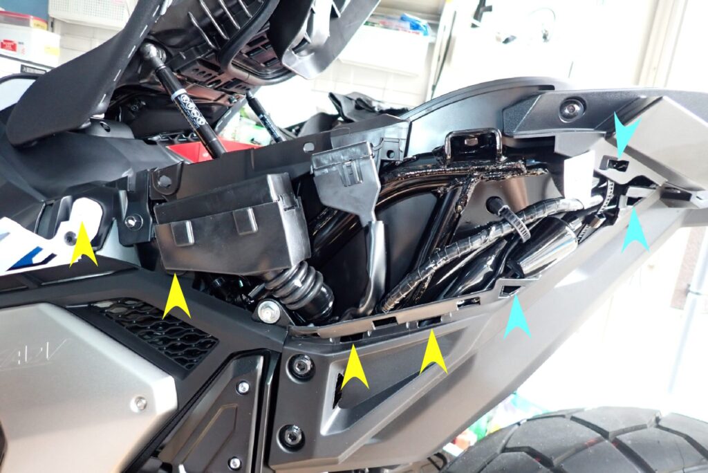 Side view of the exposed Honda X-ADV rear subframe showing grommet ports and sliding slot holes after removing the body panel.