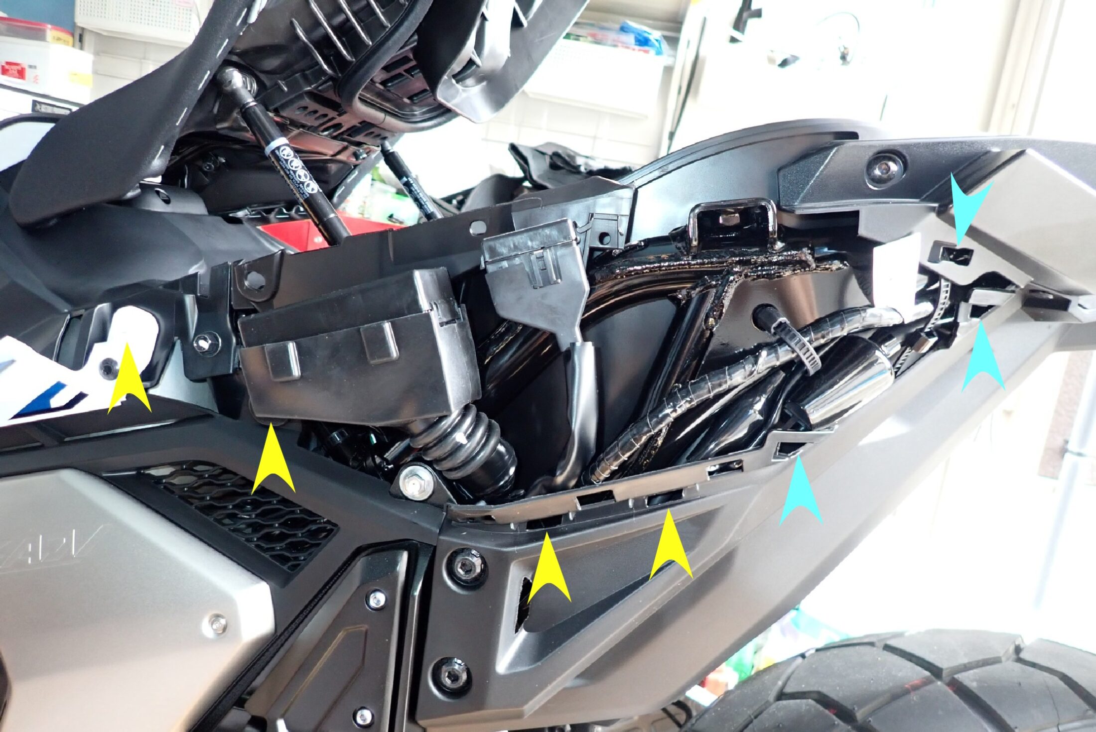 Side view of the exposed Honda X-ADV rear subframe showing grommet ports and sliding slot holes after removing the body panel.
