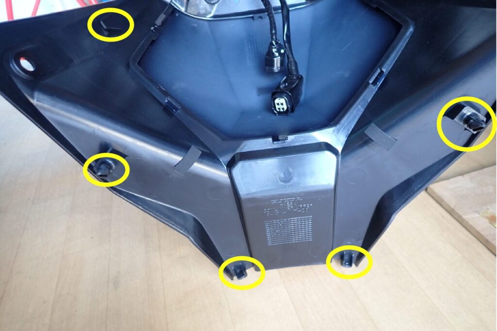 Yellow circles marking the five interlocking plastic tabs on the backside of the removed Honda X-ADV center cowl.