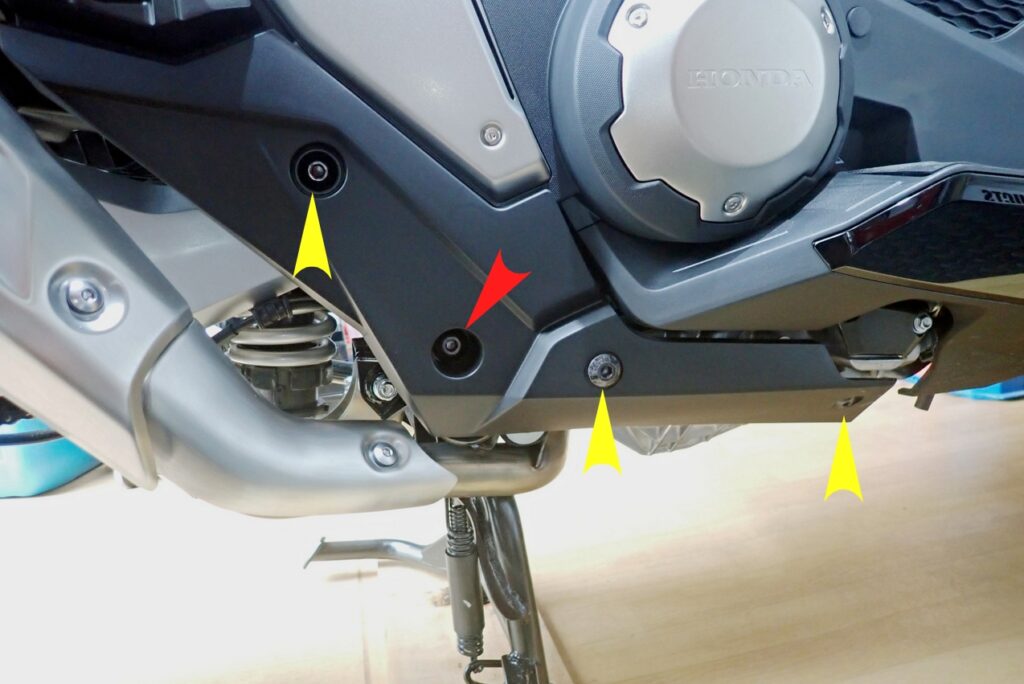 Close-up view of the right-side lower plastic cowl panel on a Honda X-ADV motorcycle before disassembly.