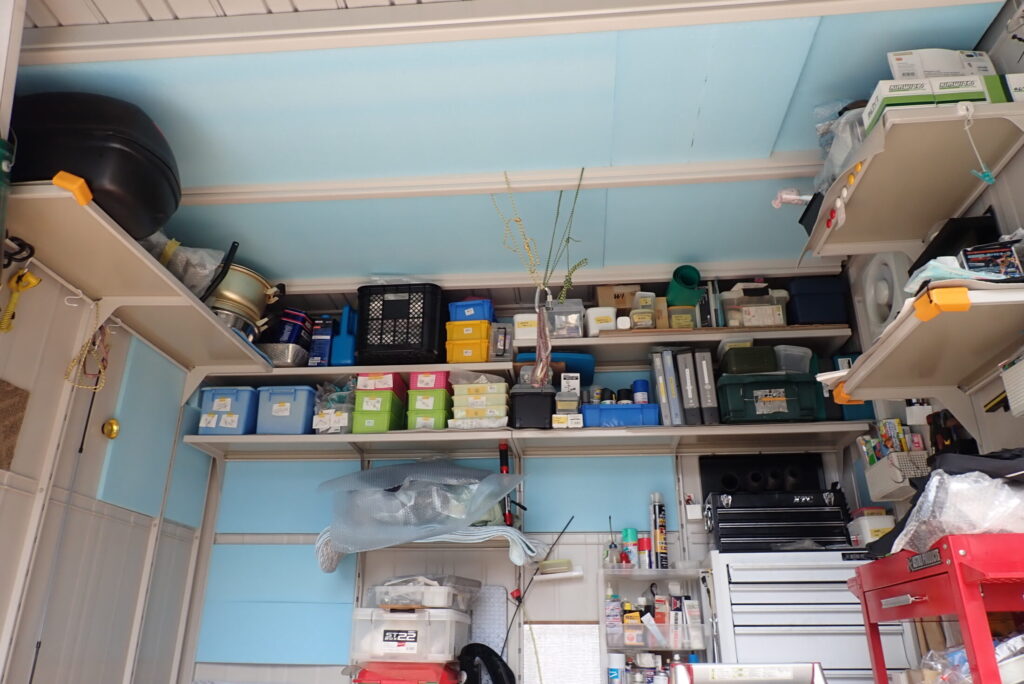 The full interior view of the motorcycle storage garage with the ceiling and back wall completely covered and insulated with light-blue Styrofoam panels.