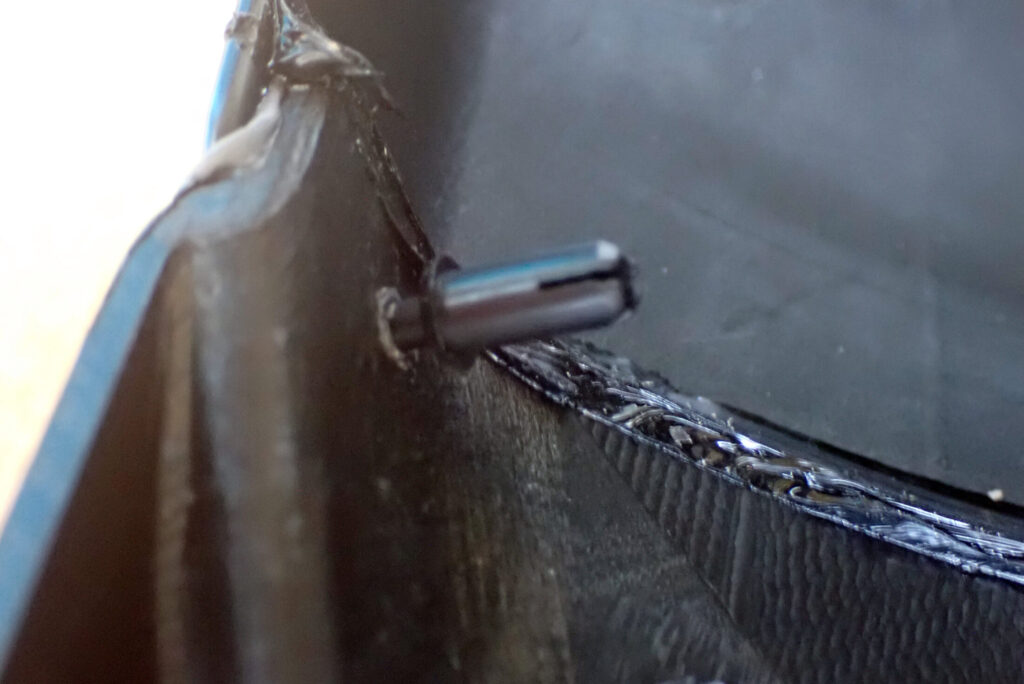 An inner look at a plastic locking pin fully inserted through the overlapping joint of a motorcycle front fender extender.