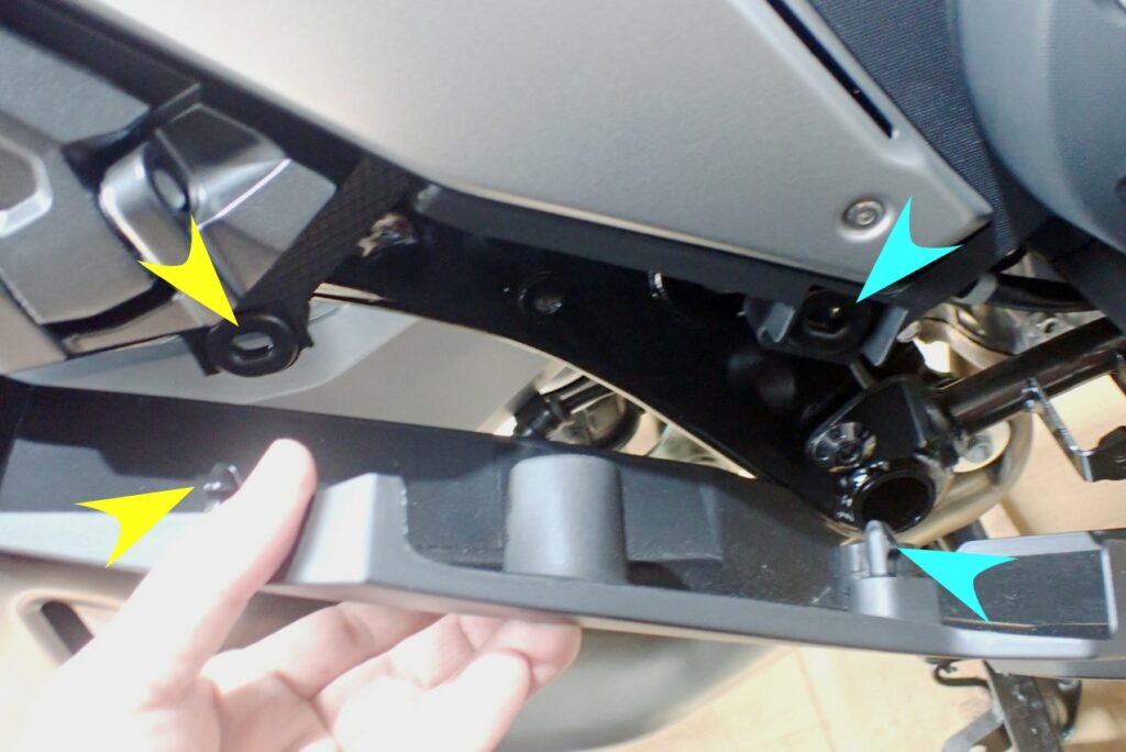 A hand carefully detaching and pulling away the right-side lower body panel cowl from the Honda X-ADV chassis.