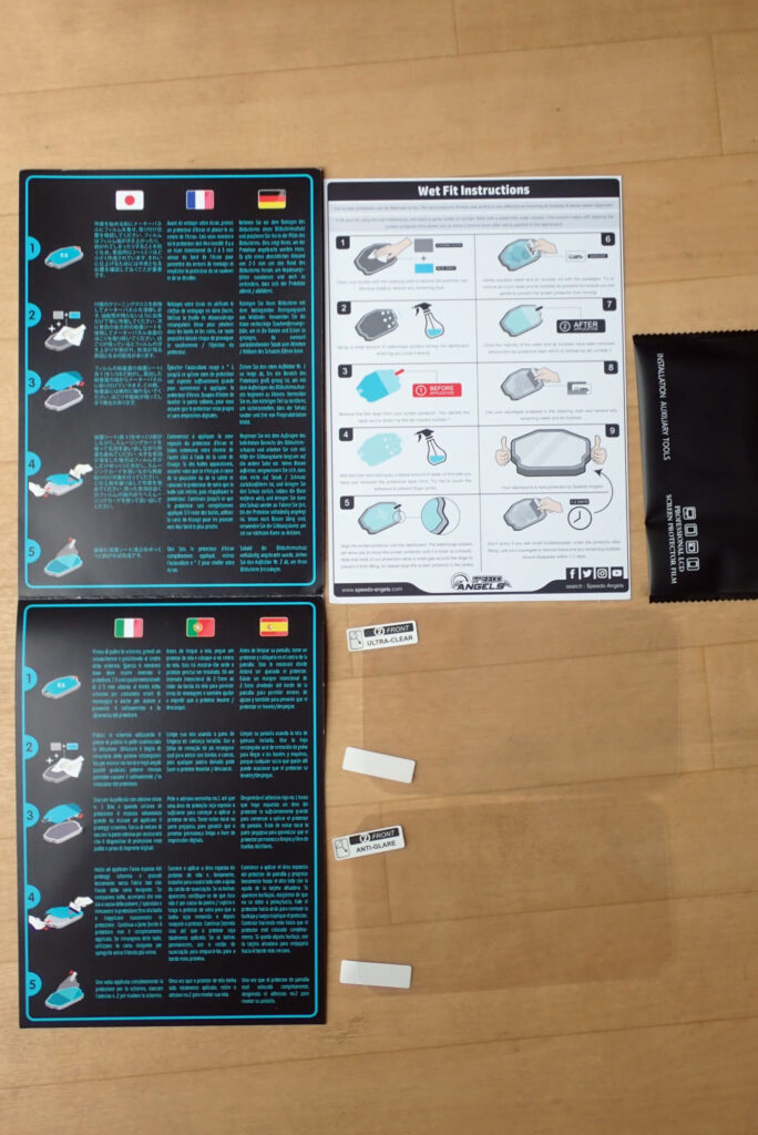 Full contents of the Speedo Angels dashboard protection kit including wet fit instructions, cleaning cloth, ultra-clear and anti-glare film sheets.