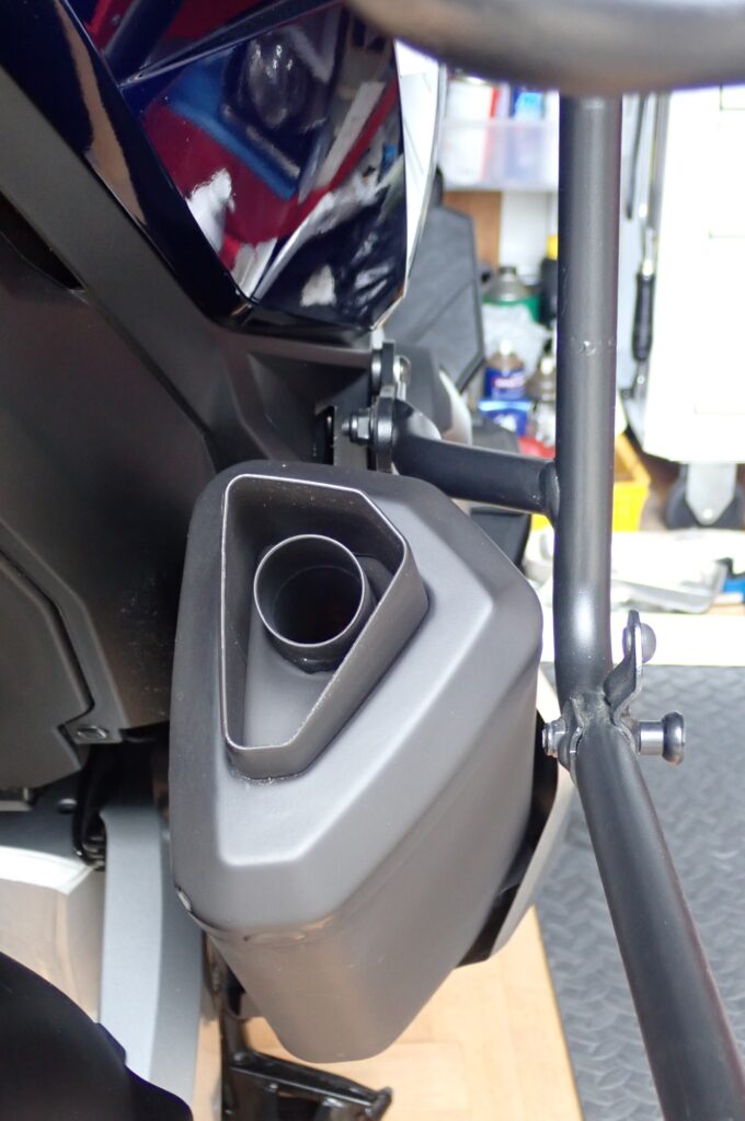 Angled close-up of tight clearance between GIVI PLO1188MK rack and motorcycle muffler