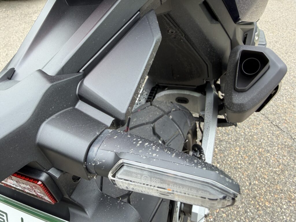 Coarse sand particles and gravel dirt on swingarm and turn signals before splash guard install