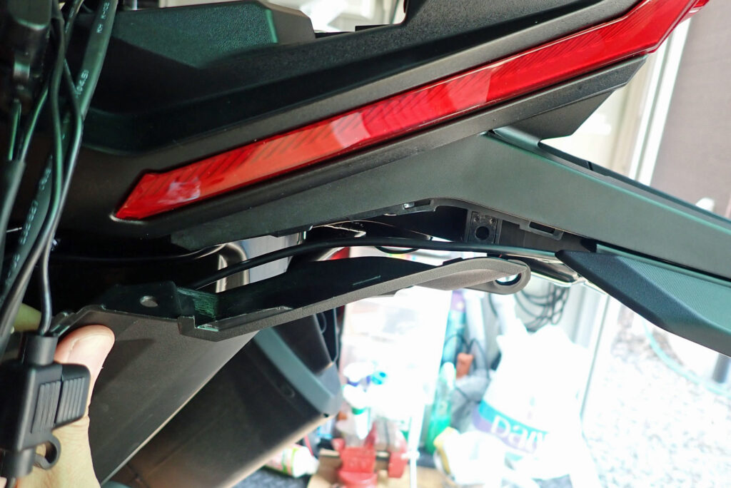 Dashcam cable inserted into the gap behind the removed screw