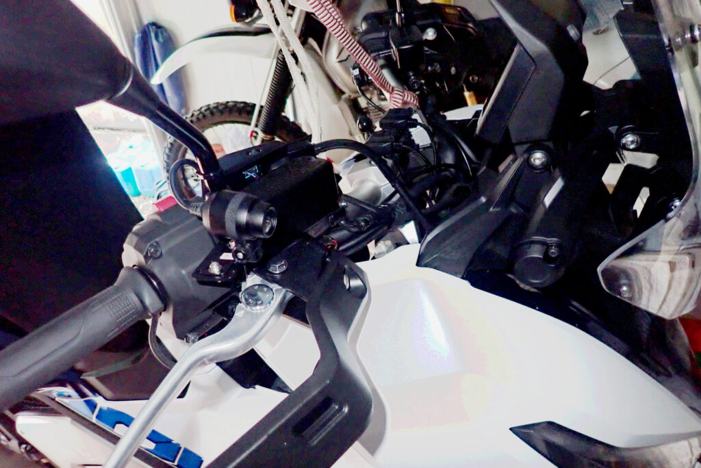 Completed installation of front dashcam camera neatly tucked under Honda X-ADV right mirror