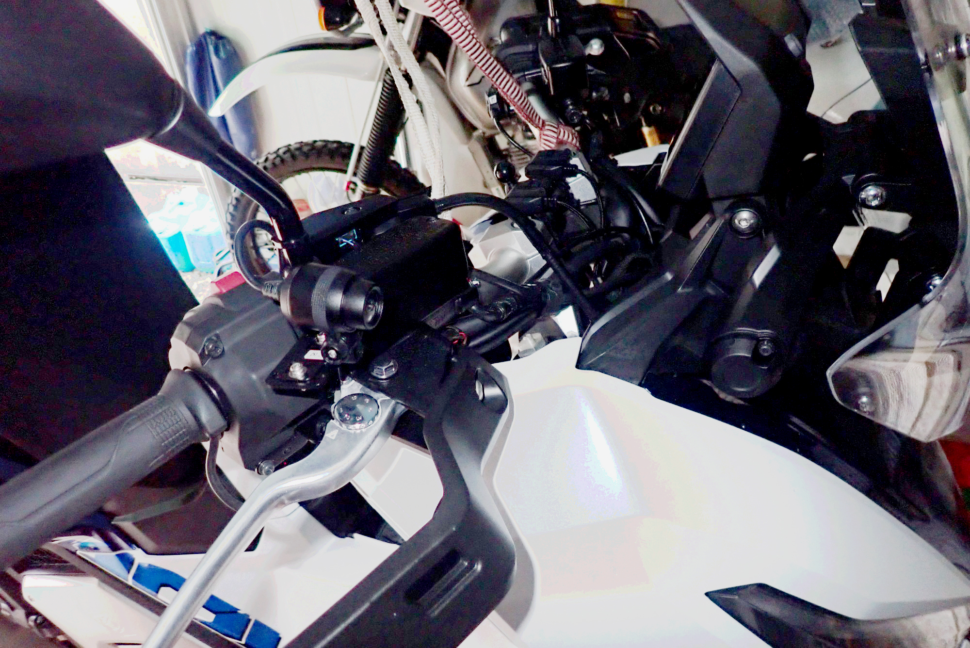 Completed installation of front dashcam camera neatly tucked under Honda X-ADV right mirror