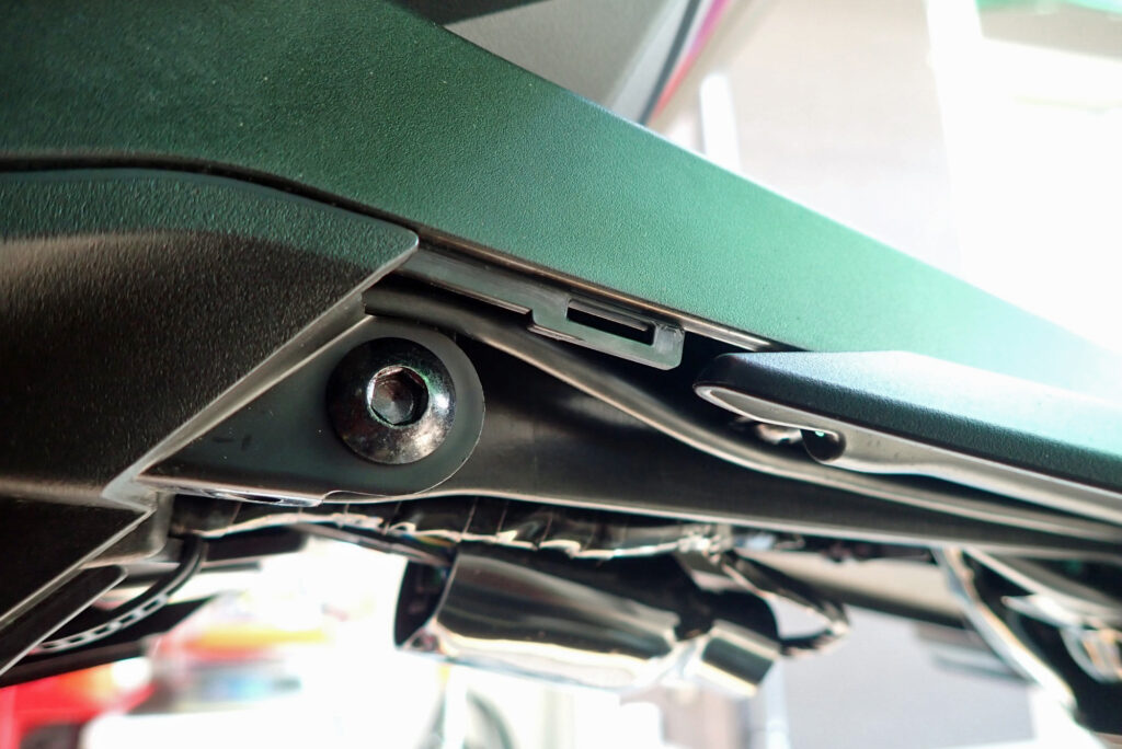 Screw reinstalled with the dashcam cable safely positioned above the screw thread