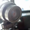 Close-up of dirty front camera lens clouded with dried road grime