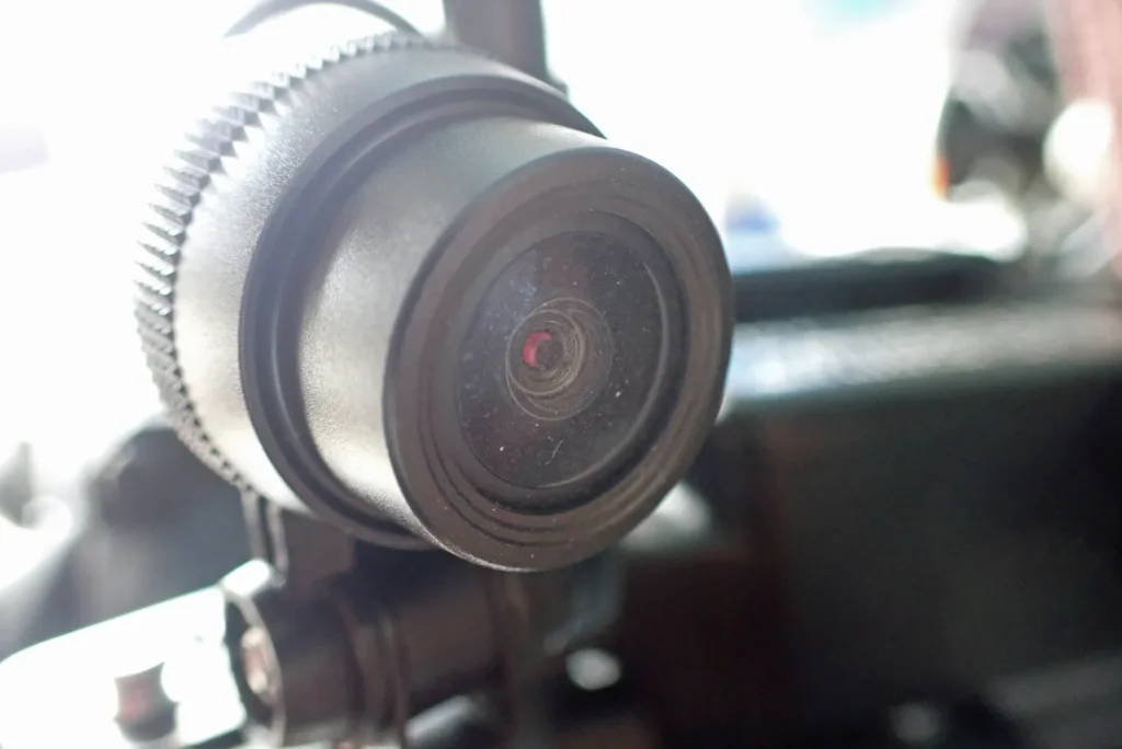 Close-up of dirty front camera lens clouded with dried road grime