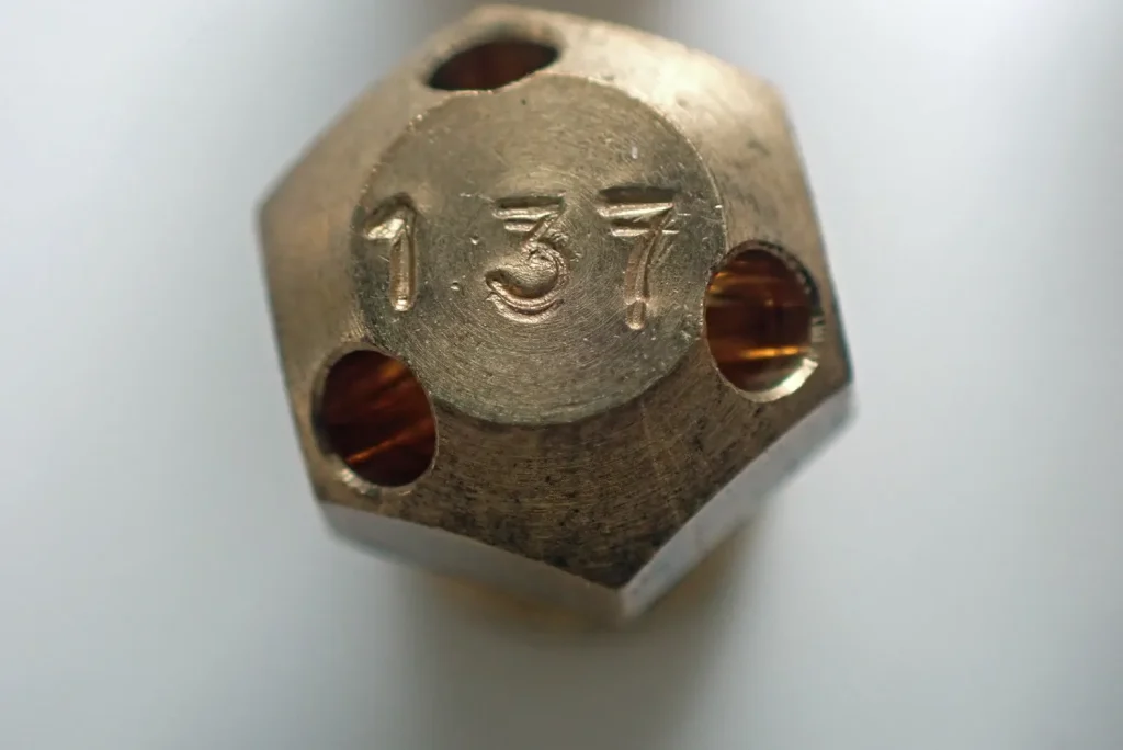Macro shot of main jet inlet hole under 1mm featuring precise chamfered machining