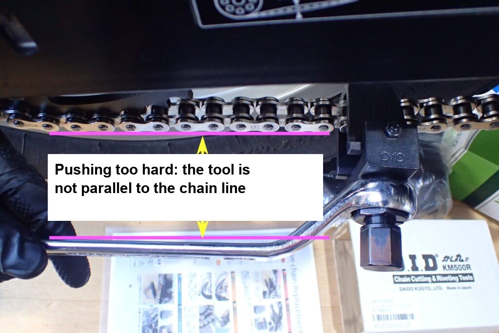 Staged photo: the chain tool is not parallel to the chain line because of pushing too hard