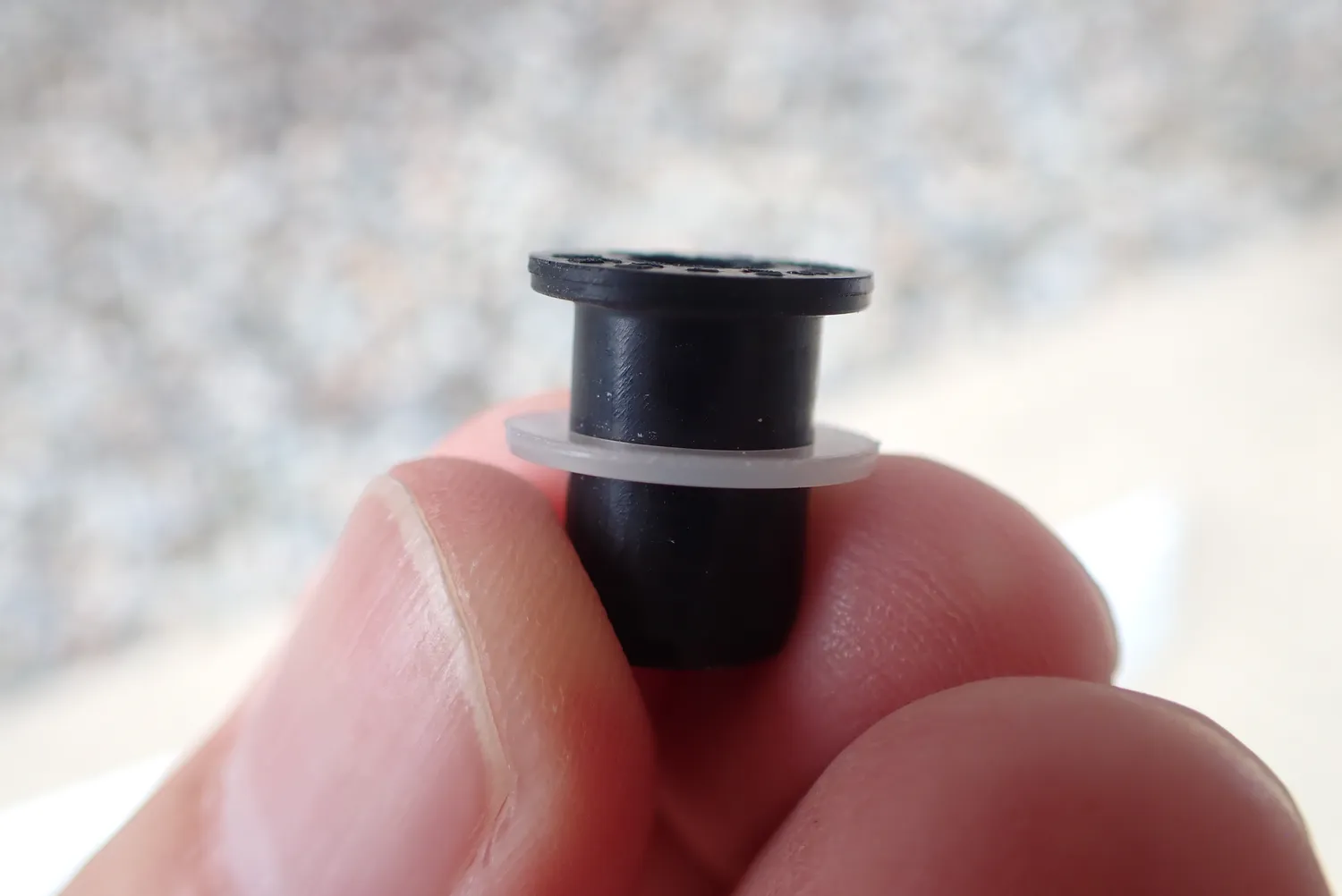 黒いゴム製ウェルナットに半透明の薄い樹脂ワッシャーを通した状態