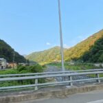 橋の上から見た宮川と、川沿いの家並みと山