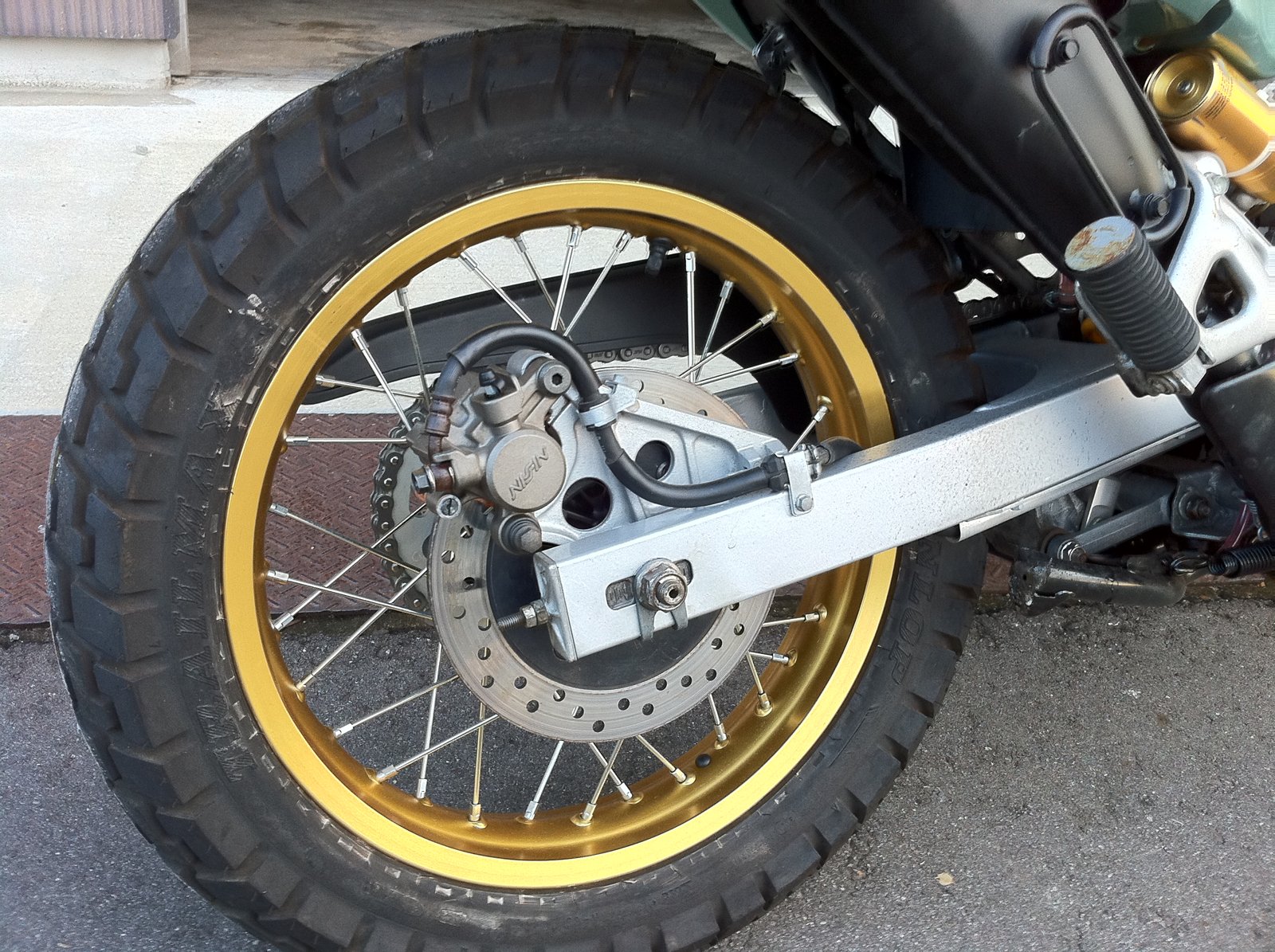 車体に付けた金色のリムのリアホイールとスイングアーム