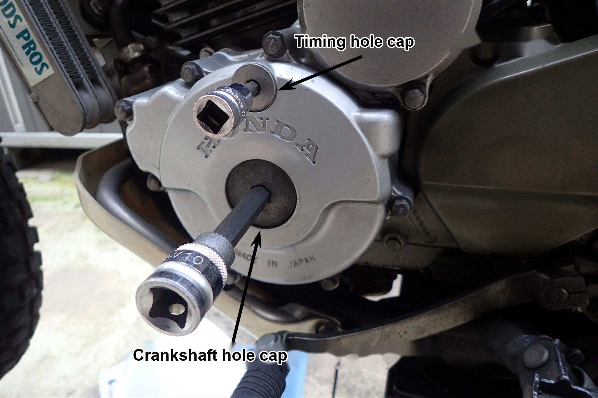 Sockets fitted to the crankshaft hole cap and timing hole cap on the left side of the XR250 engine.