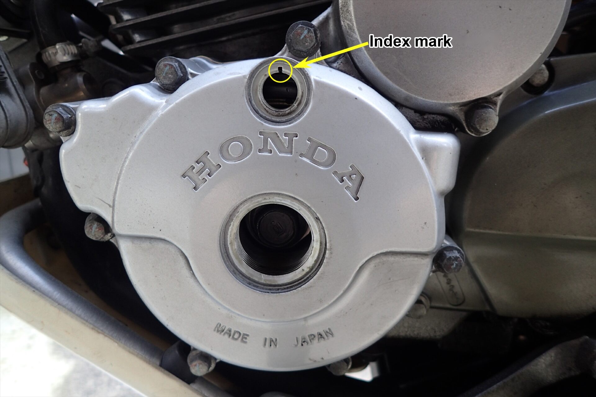 The XR250 with the crankshaft hole cap and timing hole cap removed; the index mark inside is visible.